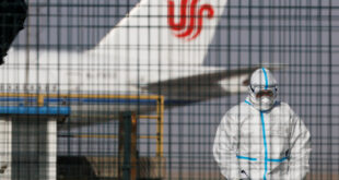 عامل يرتدي بدلة واقية بالقرب من طائرة تابعة لشركة طيران أير تشاينا في مطار بكين في 6 يناير 2023