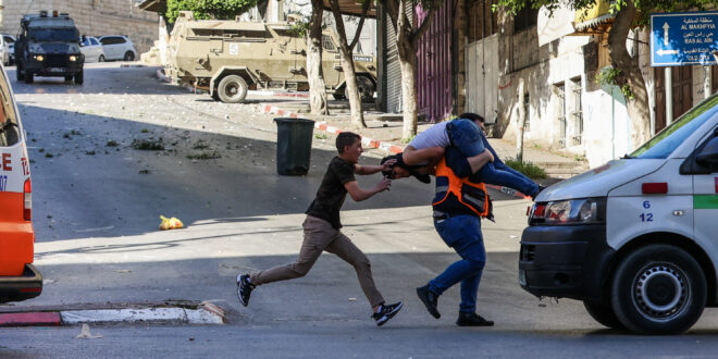 مسعف ينقل جريحا خلال اشتباكات بين القوات الإسرائيلية وفلسطينيين في نابلس. 4 مايو 2023